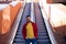 A handsome young man with blue eyes and beard stands next to an escalator in a shopping mall. The man makes different poses and