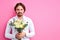 handsome young man with a bouquet of flowers waiting on a date staying on pink background