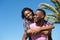 Handsome young man carrying woman on his back outdoors