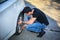 Handsome Young Man Changing Tires of his Car