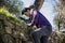 Handsome young man climbing stone wall