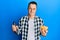 Handsome young man drinking a pint of beer holding chips smiling with a happy and cool smile on face