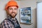 handsome young man electrician working on switchboard of house building construction site