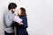 Handsome young man giving present to beautiful woman at home. A girl going to kiss her boyfriend to thank for a present. Beautiful