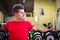 Handsome young man in gym sitting on dumbbells rack