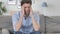 Handsome Young Man with Headache Sitting Tense on Couch