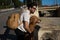 A handsome young man with his brown golden retriever dog leaning on the railing overlooking the river. They are on holiday in