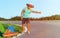 Handsome young man hitch-hiking along a rural mountain road - Hiker guy with luggage and longboard try to stop a car.