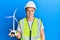 Handsome young man holding solar windmill for renewable electricity looking positive and happy standing and smiling with a