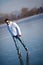 Handsome young man ice skating outdoors on a pond