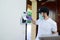 Handsome young man installing anti burglary alarm at a client house with a surgical mask and gloves COVID19 coronavirus