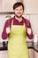 Handsome young man in the kitchen wearing apron holding a beater