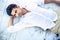 Handsome young man lying on a white wooden surface.