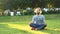 Handsome young man meditating on green grass. Concept. Man sitting on fresh green lawn in the city park on a summer