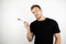 Handsome young man office worker wearing black t-shirt holding marker for notes writing isolated white background