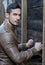 Handsome young man pressing fists on wood planks wall