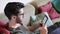 Handsome young man reading ebook on sofa