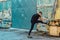 Handsome young man, runner streching on rough wall and door. Fitness, workout, sport, lifestyle concept