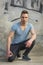 Handsome young man sitting on concrete with ripped jeans