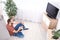 Handsome young man sitting on floor and watching TV