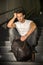 Handsome young man sitting on stairs\' granite steps