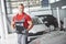 A handsome young man speaks at a car dealership, repairing a car in a workshop.