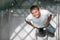 Handsome young man in a staircase, looking up