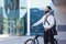 Handsome young man standing with his bicycle