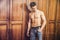 handsome young man standing shirtless against wardrobe