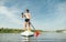 Handsome young man standing on sup board with paddle in hand on water. Active rest on a rowing board on the river. Guy swims down