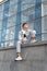 Handsome young man in stylish clothes. Portrait of student guy resting on the street. Urban. Vertical frame