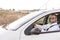 Handsome young man at sunset inside the car looking on the mirror. Travel and lifestyle. Outdoors