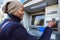 Handsome young man taking cash from ATM with credit card.