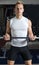 Handsome young man training biceps lifting barbell