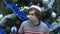 Handsome Young Man Wearing Santa Hat and Eavesdropping on Christmas Tree Background.