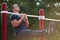 Handsome young man working out on crossbars on a park background. Physical training concept.