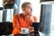 Handsome young man working with tablet, thinking, looking out the window, while enjoying coffee in cafe