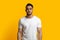 Handsome young middle eastern guy posing on yellow studio background