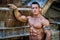 Handsome young muscle man with hand on rusty metal structure