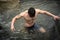 Handsome young muscle man standing in water pond, naked