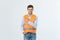 Handsome young professional engineer man over grey wall wearing orange vest amazed and surprised looking and pointing