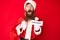 Handsome young red head man with long beard wearing santa claus costume holding christmas text in shock face, looking skeptical