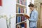 Handsome young student  with glasses lost in reading a book in home library