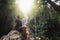 Handsome young stylish man in black t-shirt and sunglasses is engaged in trekking in the green jungle