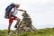 Handsome young tourist man with backpack making pyramid pile of