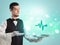 Handsome young waiter in tuxedo holding healthcare icons on tray