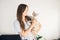 Handsome young woman is holding blue eyed Devon Rex cat. Spending time with cat, boosting your mood and lowering your stress