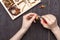 Handwork at home, the girl makes jewelry hands on the table