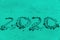 Handwriting 2020 text on the sand in trendy mint color