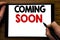 Handwriting Announcement text showing Coming Soon. Business concept for Message Future Written on tablet laptop, wooden background
